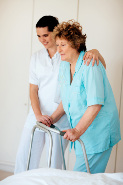 caregiver assisting the senior female to walk