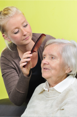caregiver combing the hair of the senior female